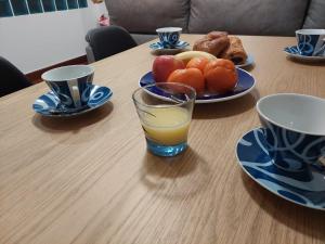 a table with a plate of fruit and a glass of orange juice at Nuevo, junto al Ayuntamiento y Casco Viejo in Bilbao +16 photos