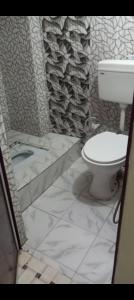 a bathroom with a toilet and a stone wall at KUMBH HOME STAY NEAR ARAIL GHAT Sangam in Allahābād