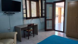 a living room with a desk and a tv and a couch at La Rosa dei Venti B&B in Chia