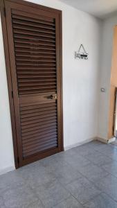 a large wooden door in a room with a tile floor at La Rosa dei Venti B&B in Chia