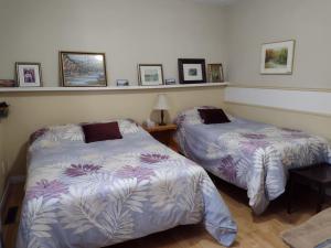 a bedroom with two beds and a table at Gîte Marie-Claire in Petit-Saguenay