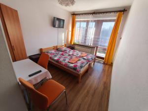 科尔别卢夫Panorama的小房间设有一张床、一张桌子和椅子