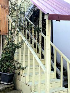 una escalera de madera que conduce a una casa con porche en Old Town-Booking Apartment, en Tiflis 8 fotos más
