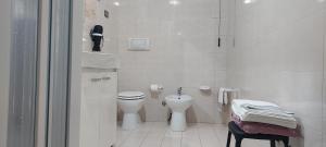 a white bathroom with a toilet and a sink at La Rosa dei Venti B&B in Chia