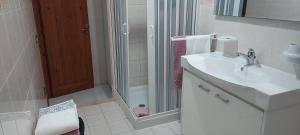 a white bathroom with a sink and a shower at La Rosa dei Venti B&B in Chia