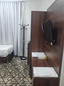 a bedroom with a bed and a tv in a room at فندق مواسم العزيزية in Al ‘Azīzīyah