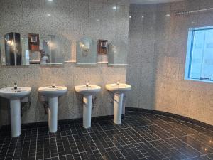 a public bathroom with three sinks and mirrors at فندق مواسم العزيزية in Al ‘Azīzīyah +22 photos