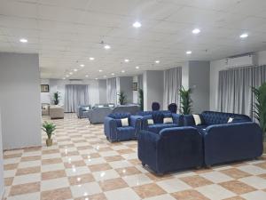 a waiting room with blue couches in a lobby at فندق مواسم العزيزية in Al ‘Azīzīyah