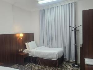 a hotel room with two beds and a window at فندق مواسم العزيزية in Al ‘Azīzīyah