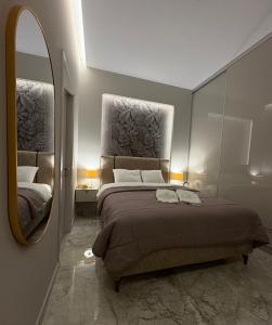 a bedroom with a large bed and a mirror at Central Luxury Apartment Maison De Luxx A11 in Larisa