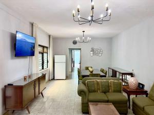 a living room with a couch and chairs and a tv at Villa by Centro Medico Occidente 3 br in Guadalajara