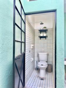 a bathroom with a toilet and a blue wall at Villa by Centro Medico Occidente 3 br in Guadalajara