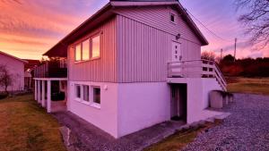 a large white house with a red roof at Rancho Apartment in Langevåg in Sula