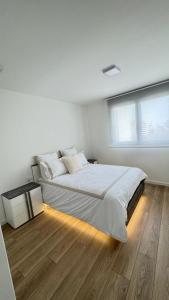 a white bedroom with a large bed and a window at Apartamento Luxury in Valencia +14 photos