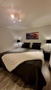 a bedroom with a large bed and two lamps at Rancho Apartment in Langevåg in Sula