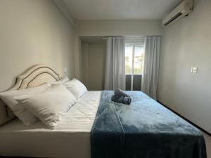 Un dormitorio con una cama con un zapato. en Ap a alguns passos da praia do Bosque | ROGR104, en Rio das Ostras