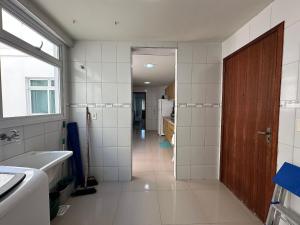 Un baño con inodoro, lavabo y puerta. en Ap a alguns passos da praia do Bosque | ROGR104, en Rio das Ostras 38 fotos más