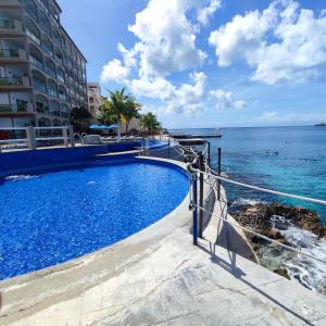 una piscina con l'oceano sullo sfondo di The Queen of Cozumel - Urban Empire En-suite City View - for Couples in Mind a Cozumel
