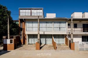 ein Gebäude mit zwei Garagentüren davor in der Unterkunft Casa 2Q c churrasq a 600m do mar RVL118 in Canto Grande