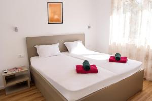 a bed with two red pillows on top of it at Villa Mária Marta in Mirce