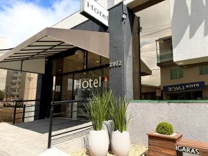 a hotel with awning in front of a building at Igaras Hotel - Centro de Otacílio Costa, 49km de Lages in Otacílio Costa