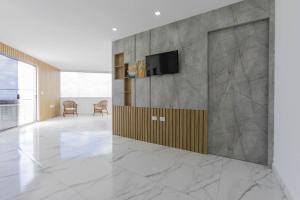 a living room with a tv on a wall at Cobertura a beira mar com piscina e churrasqueira in Praia Grande