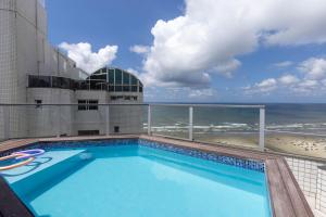 a swimming pool on top of a building with the beach at Cobertura a beira mar com piscina e churrasqueira in Praia Grande