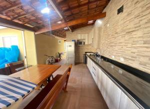 a kitchen with a wooden table and a brick wall at Casa de campo em Mairinque in Mairinque