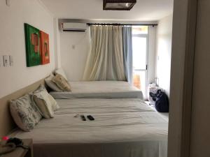 a bedroom with two beds and a window at Condomínio Lençóis Flat Resdence in Barreirinhas