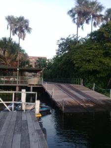 a dock with a boat in a body of water at Condomínio Lençóis Flat Resdence in Barreirinhas