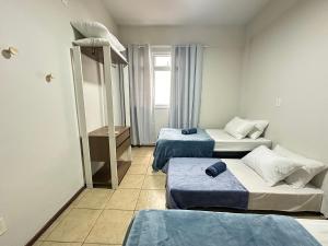 a room with three beds and a bunk bed at Ap a alguns passos da praia do Bosque | ROGR207 in Rio das Ostras