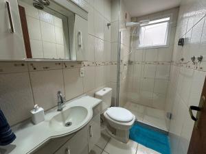 a bathroom with a toilet and a sink and a shower at Ap a alguns passos da praia do Bosque | ROGR207 in Rio das Ostras +41 photos
