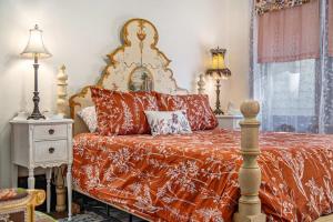 a bed with a red comforter and pillows at Classic 4BR Bowery Hill Gem Near Top Spots in Omaha