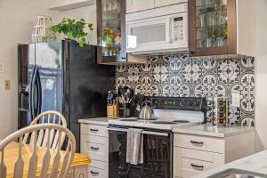 una cocina con estufa y refrigerador en Classic 4BR Bowery Hill Gem Near Top Spots, en Omaha