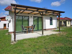 a patio with a table and chairs in front of a house at Ferienhaus Seeadler am Vilzsee in Mirow in Mirow