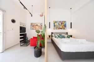 a bedroom with a king sized bed and a red chair at SUITE LUCIA in Capri