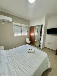 a bedroom with a large white bed with a towel on it at Zafiro VI Microcentro Con Cochera Gratis in Santa Fe