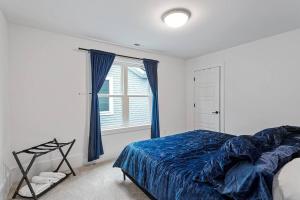 Un dormitorio con una cama azul y una ventana. en Home Near Lenovo Center and Carter Finley, en Raleigh 30 fotos más