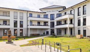 a large white building with a statue in front of it at Modernes voll möbliertes Apartment am See mit Garten, nahe BER in Bestensee