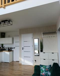 a living room with white cabinets and a door at Domek Na Wądołach in Jedlicze +25 photos