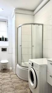 łazienka z prysznicem i pralką w obiekcie Beautiful Rooms - Wały Chrobrego w Szczecinie