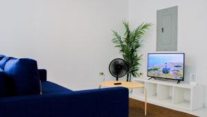 a living room with a blue couch and a tv at Arecibo Hotel 2104 in Arecibo +6 photos