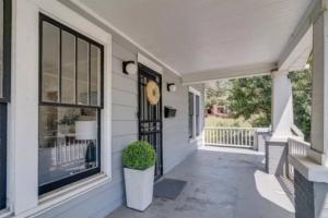 a porch with a clock on the side of a house at The Local House in Raleigh