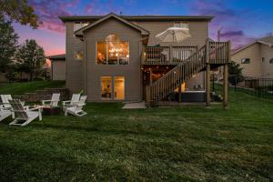 a house with a deck and chairs on the lawn at Stunning 5BR Villa Large Hot Tub & Scenic Yard in Bennington