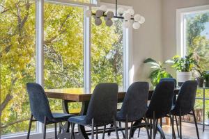 a dining room with a table and chairs and large windows at Stunning 5BR Villa Large Hot Tub & Scenic Yard in Bennington