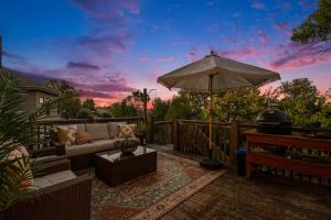 a patio with a couch and an umbrella and a piano at Stunning 5BR Villa Large Hot Tub & Scenic Yard in Bennington