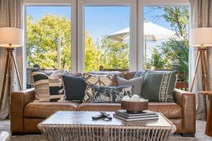 a living room with a brown couch with pillows at Stunning 5BR Villa Large Hot Tub & Scenic Yard in Bennington +74 photos