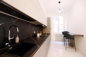a kitchen with a black counter and a sink at Duomo Florence - Esclusive Luxury in Florence