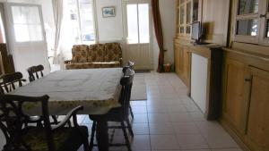 a dining room with a table and a kitchen at Sylvia's house - ground floor flat in Jarnages