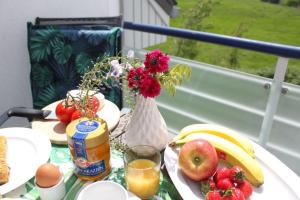 - une table avec des fruits et des jus de fruits et un vase avec des fleurs dans l'établissement Residenz Haffblick Wohnung 31, à Boltenhagen 26 autres photos